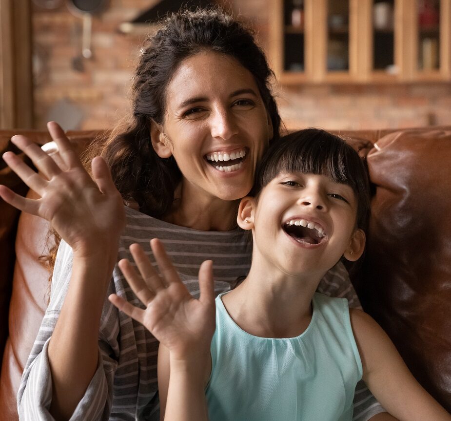 Mother and Daughter Smiling - Dentist in San Fernando A joyful mother and daughter waving and smiling together indoors - Dentist in San Fernando