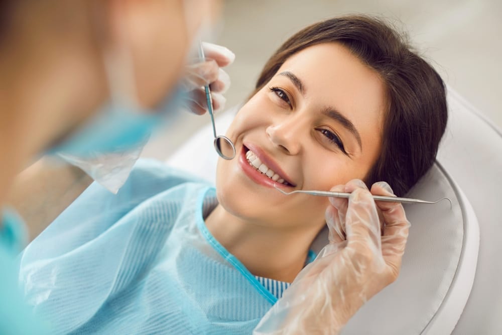 Woman Receiving Dental Treatment A smiling patient relaxes during her dental procedure, trusting in expert and gentle oral care.